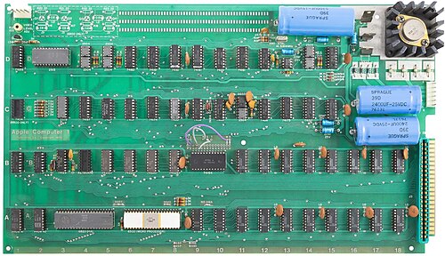 An original Apple I circuit board, populated with socketed chips on a plain green substrate.