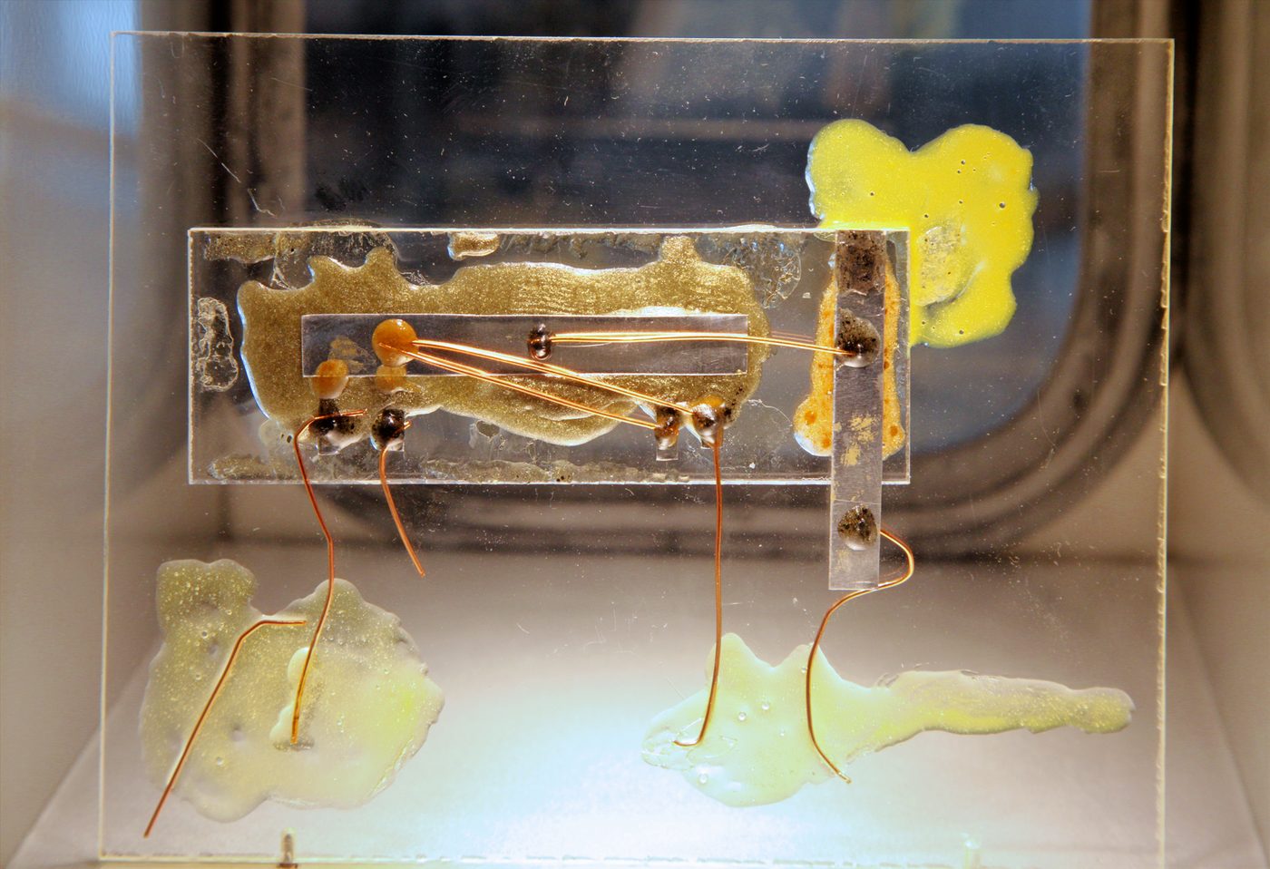 A replica of Jack Kilby's first integrated circuit, its gold bond wires visible over the germanium bar.